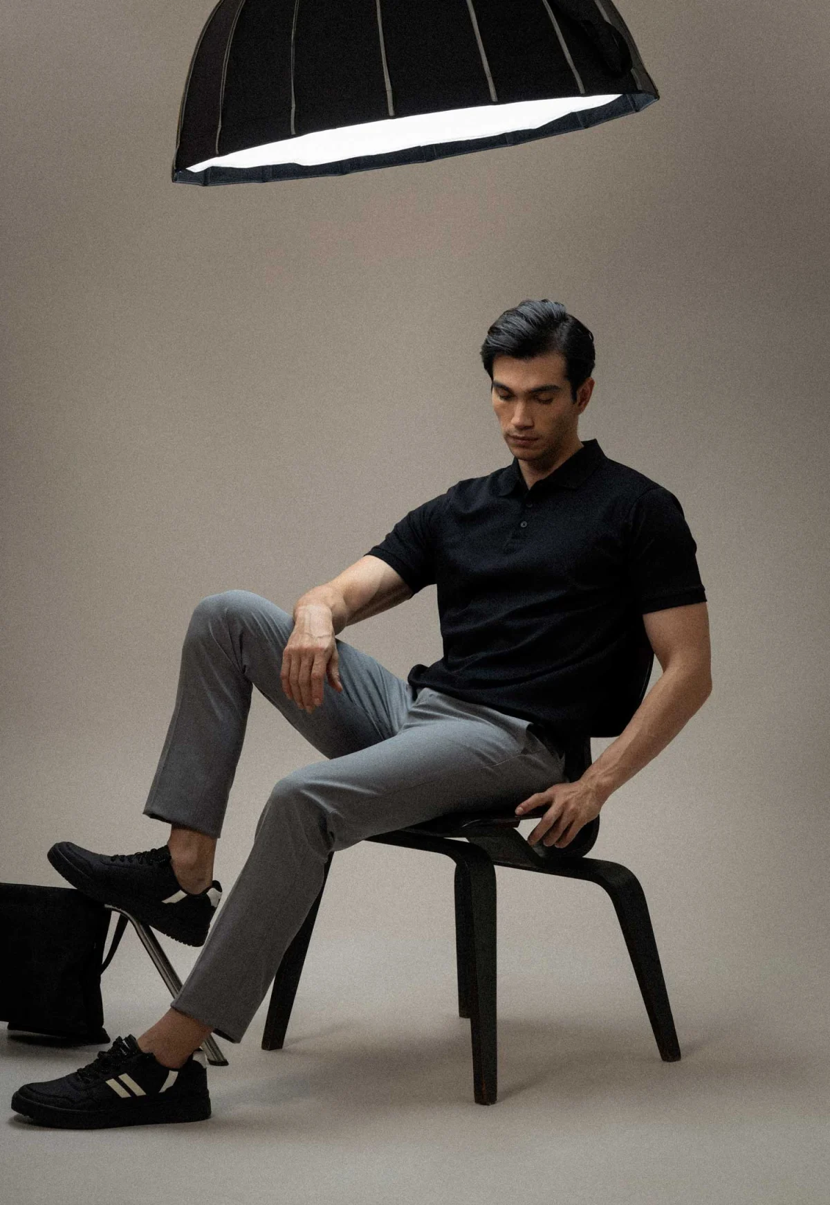 Menswear model seated under a studio light