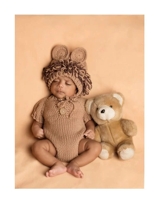 Newborn in a knitted bear outfit