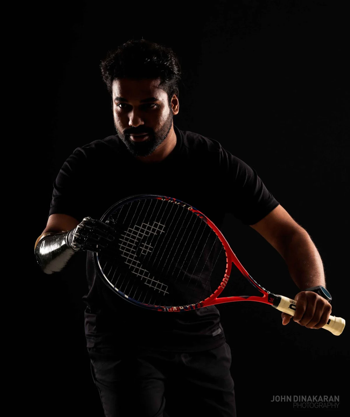 Low-key portrait of a tennis player in dramatic light