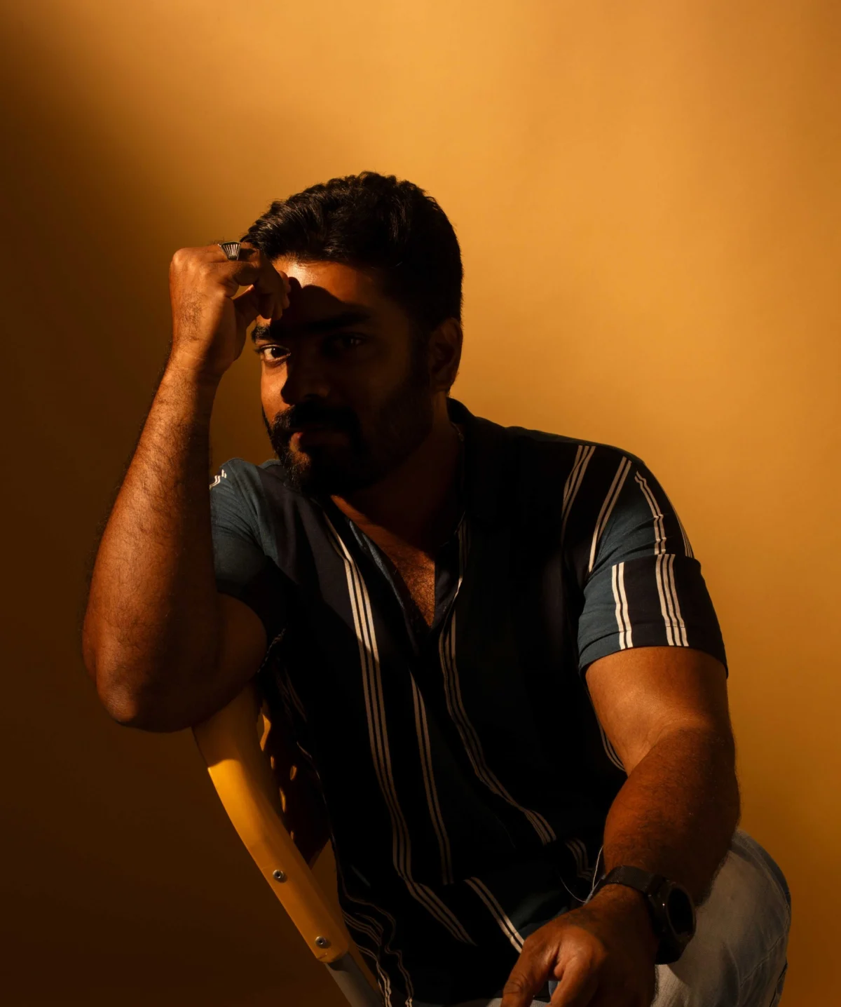 Portrait of John Dinakaran in warm studio light