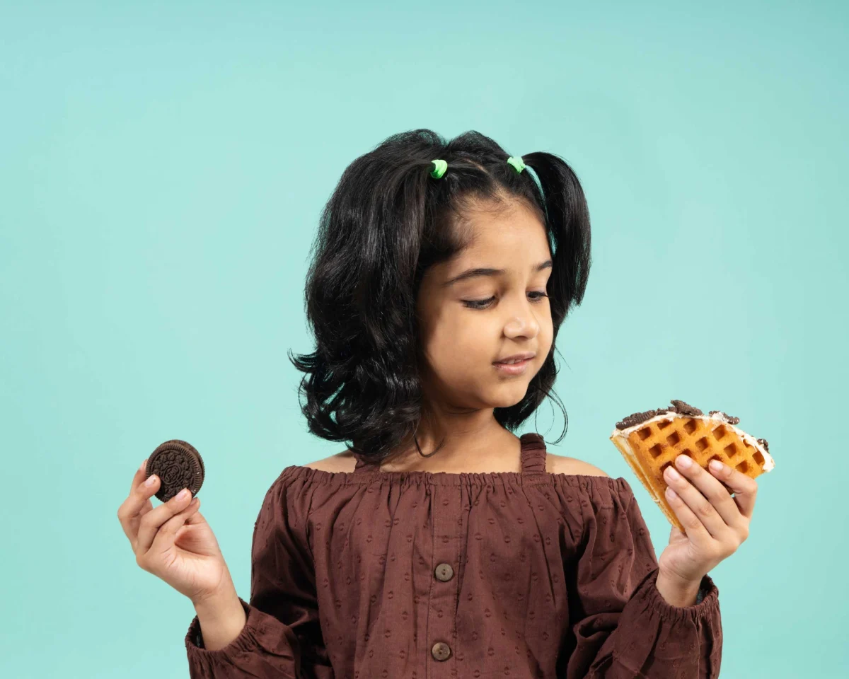 Girl with cookies and a waffle on teal