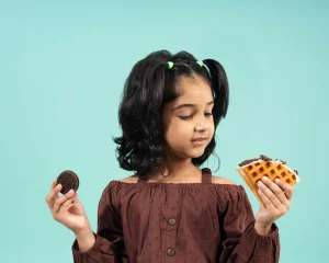 Girl with cookies and a waffle on teal